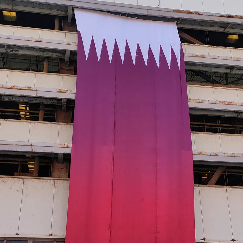 علم قطر بمقاس ضخم مطبوع ومعلّق على واجهة مبنى